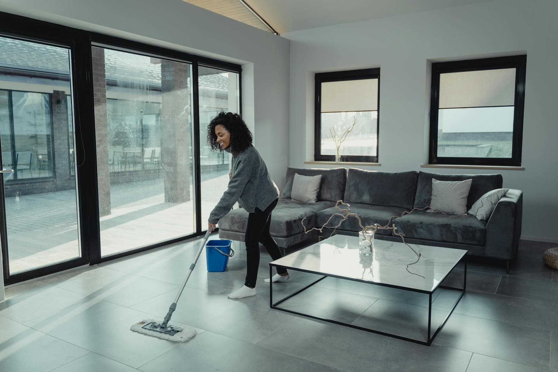 House cleaner mopping a bright, modern Connecticut apartment with large windows — How to Deep Clean a Small Connecticut Kitchen (Without Losing Your Mind)